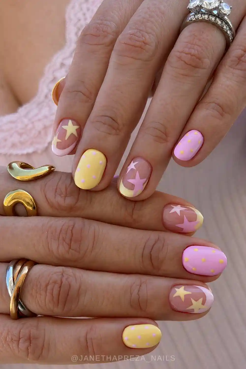 Short pink and yellow nails with dots and stars