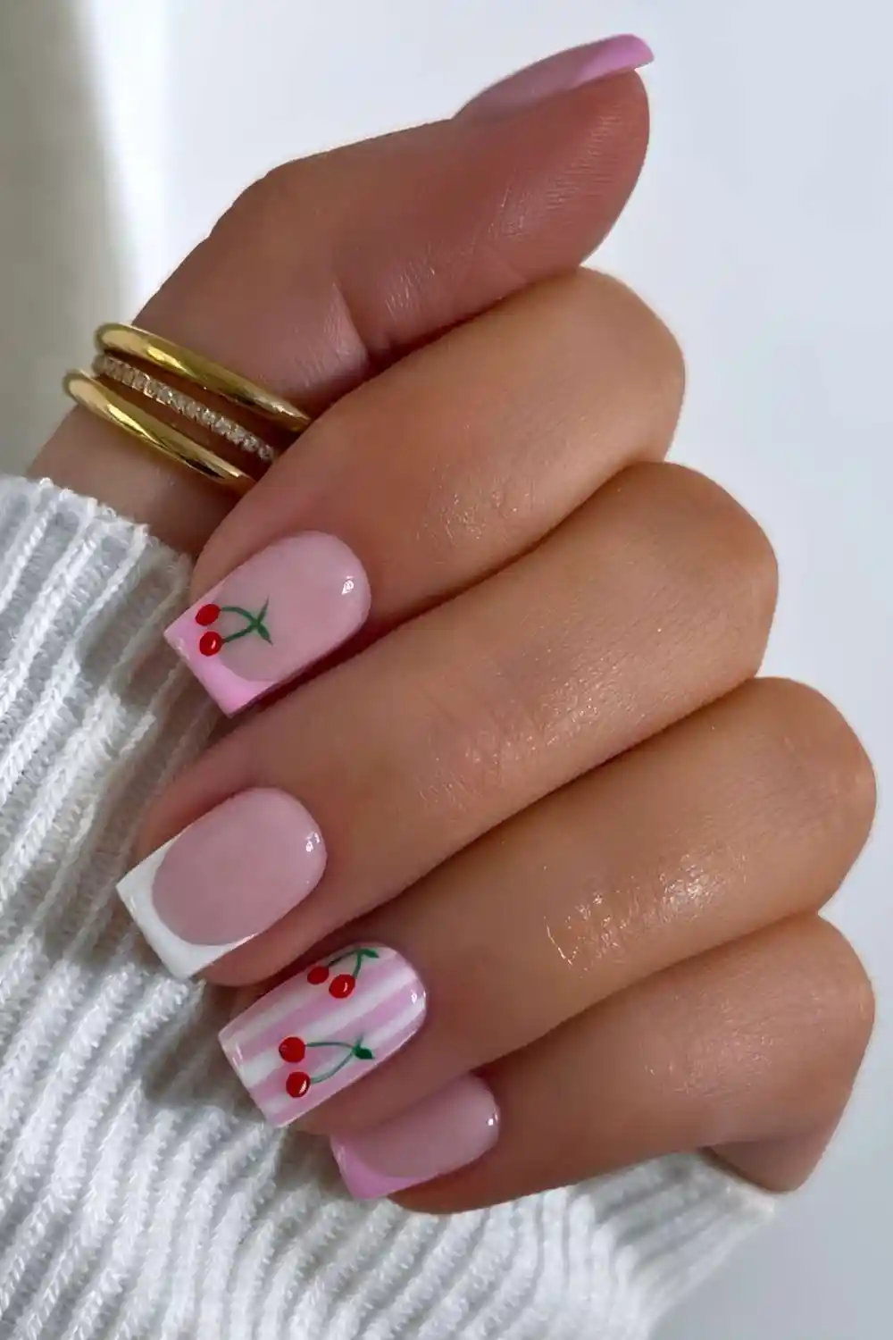 Pink and white nails with stripes and cherries