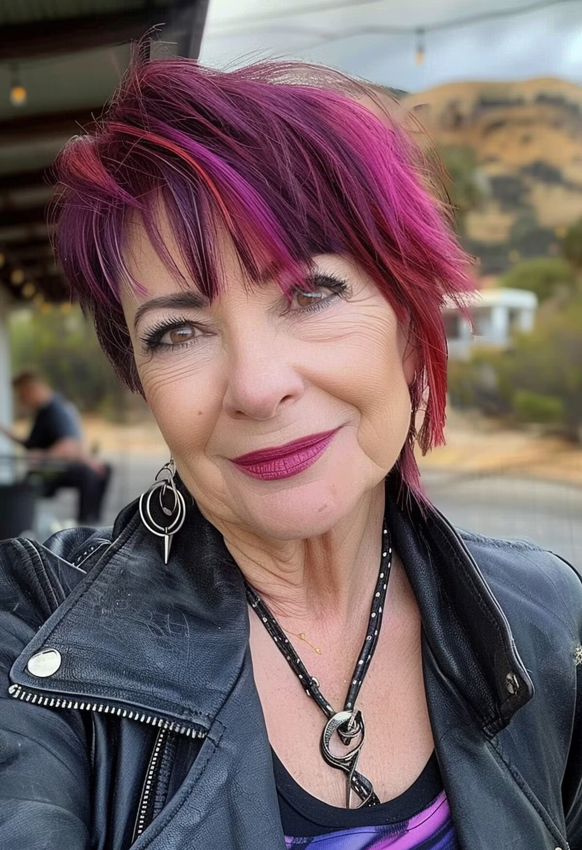 Woman over 60 with a very Edgy Pink Purple and Red haircut and Bangs