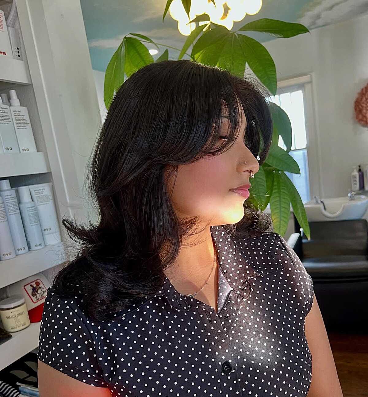 Black wavy mid-length blowout with volume at crown