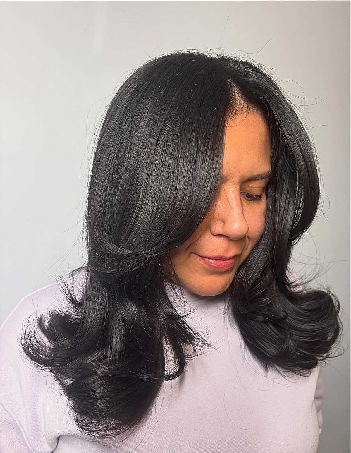 Polished black blowout with barrel curls and side part