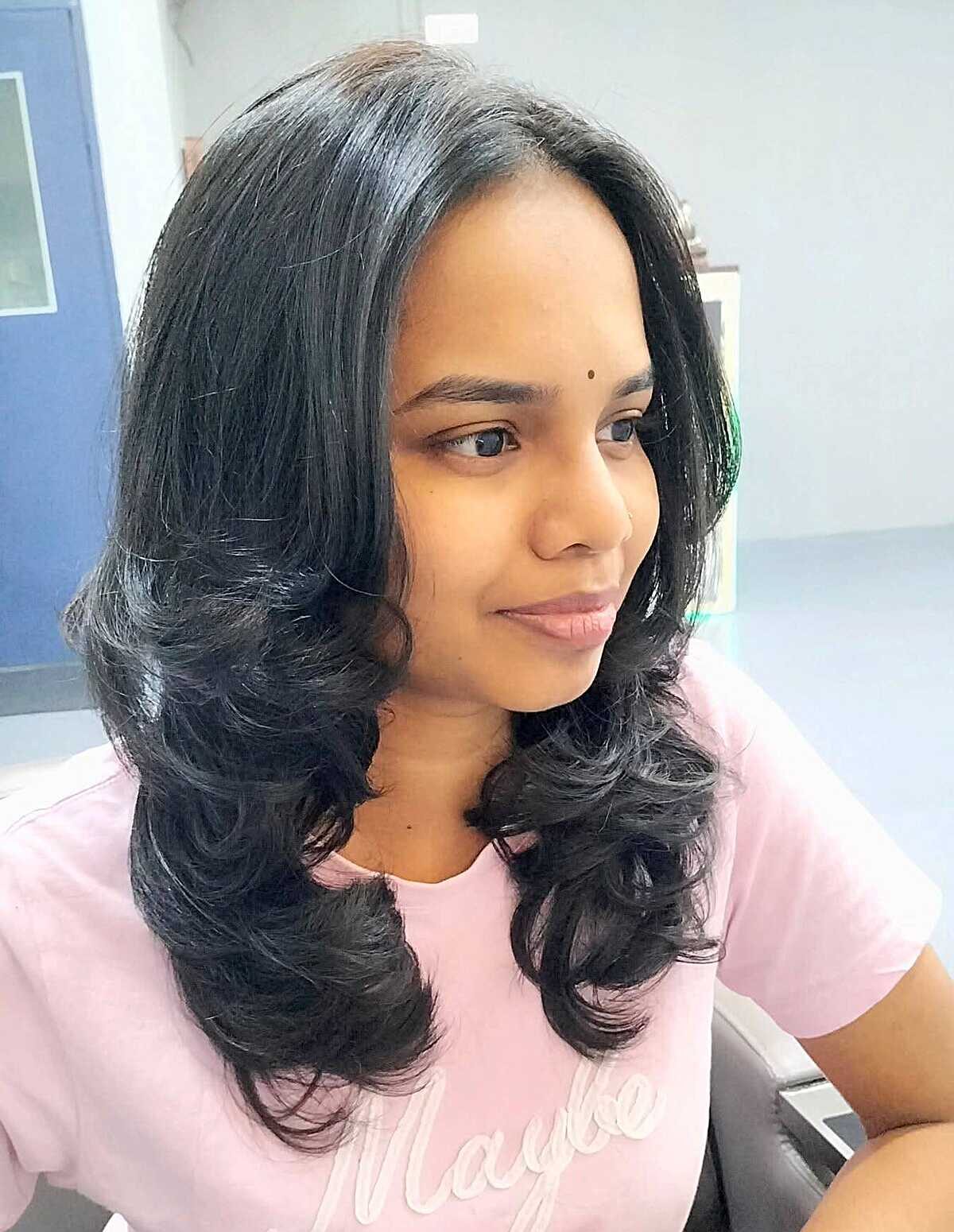 Jet black mid-length blowout with glamorous curls