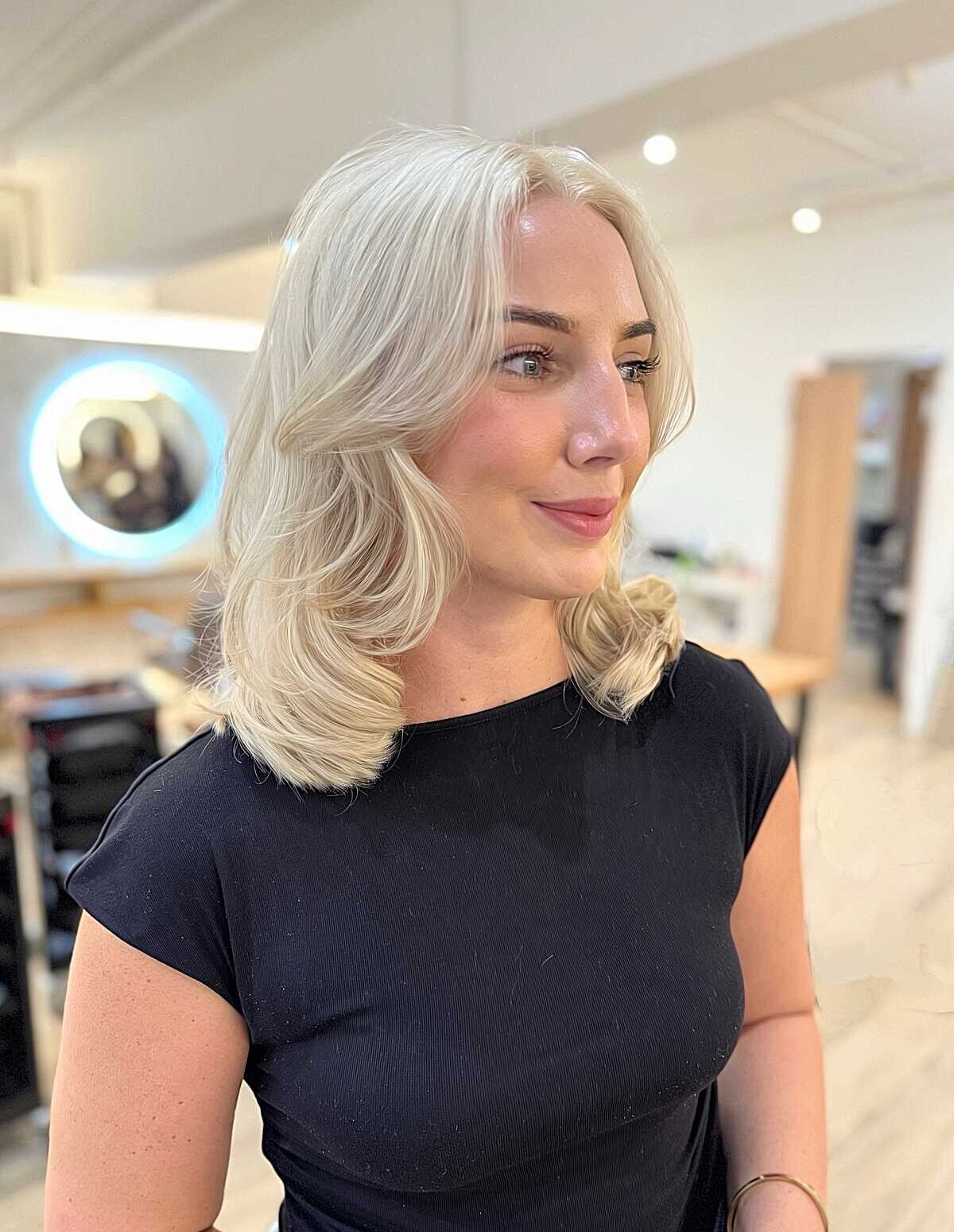 Platinum blonde mid-length blowout with flipped ends