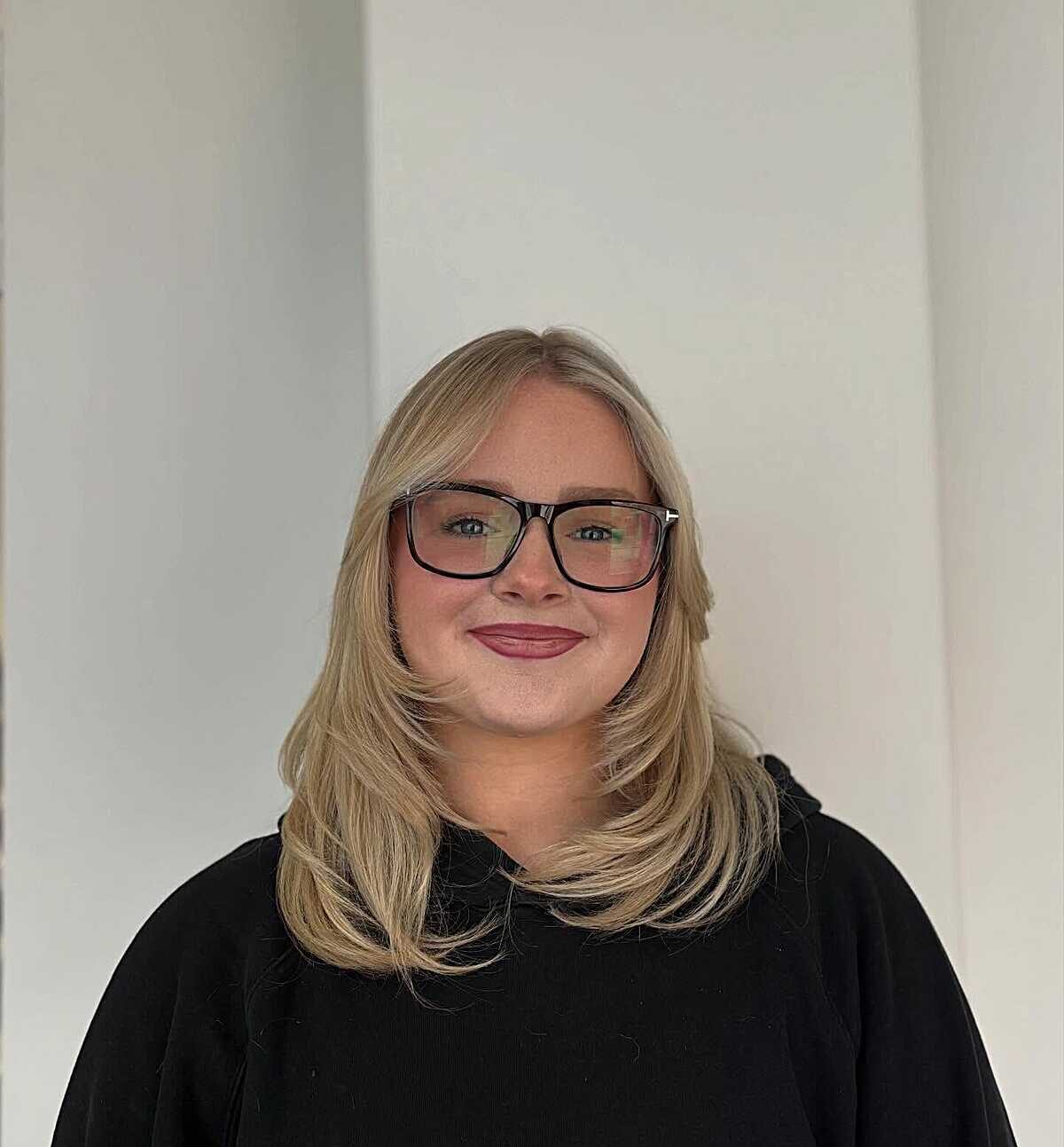 Warm blonde mid-length blowout with side-swept layers