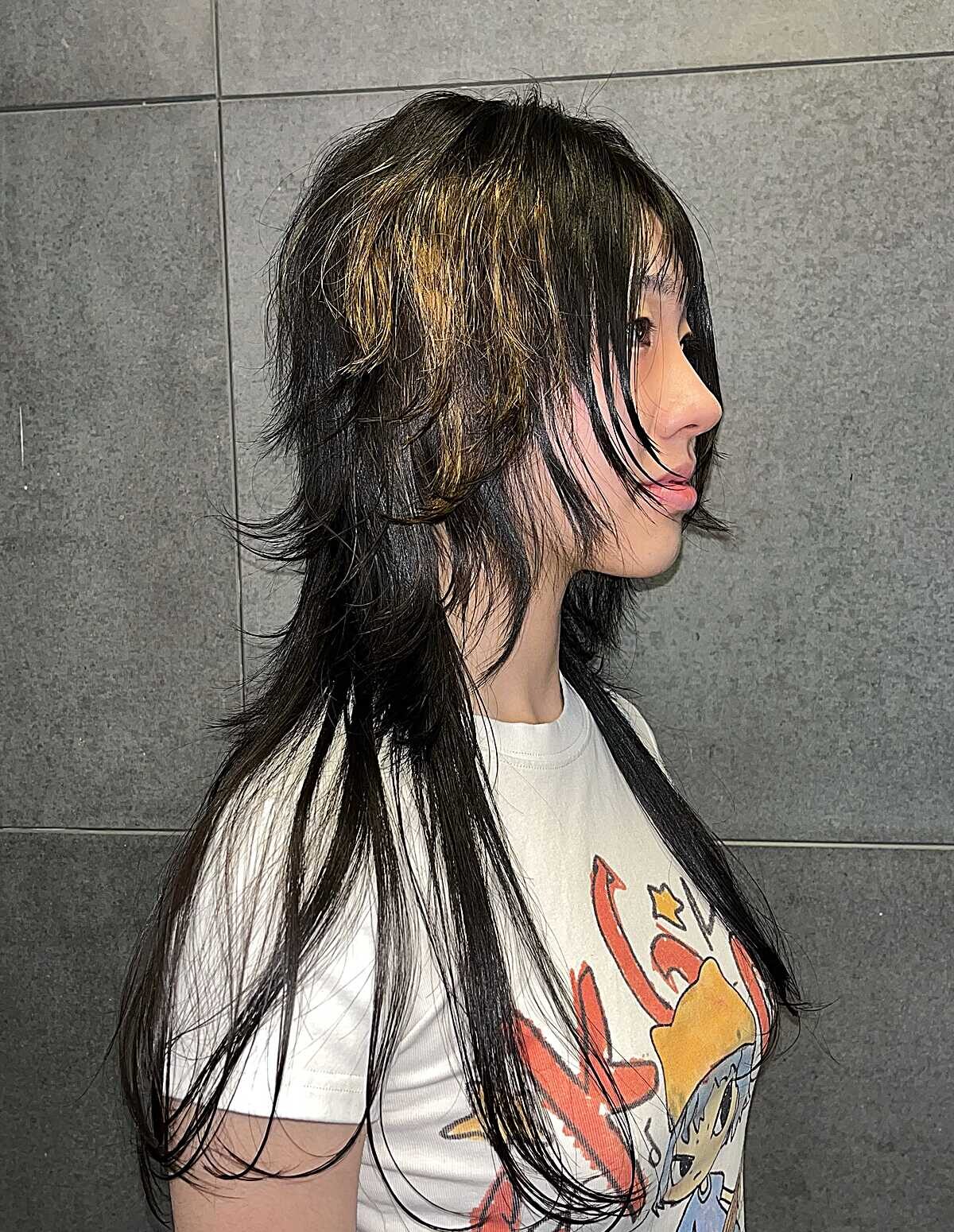 Long black wolf cut with golden face-framing highlights
