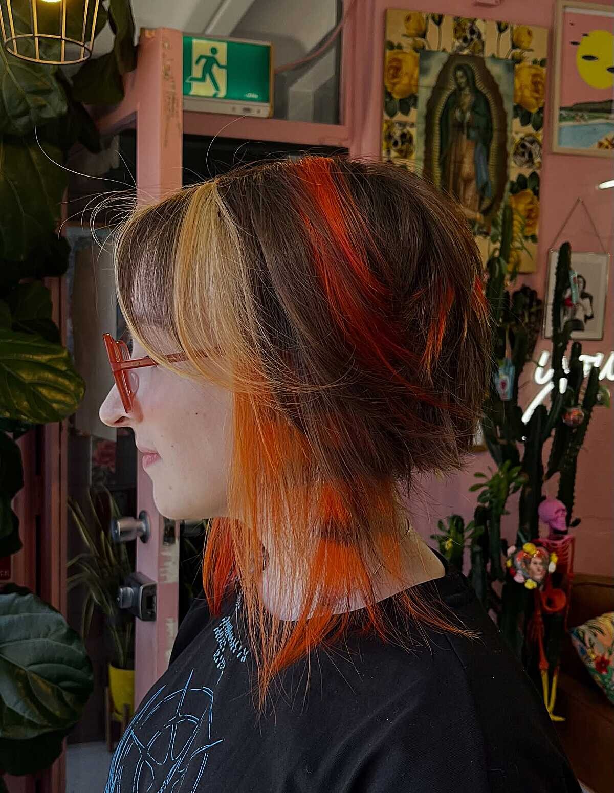 Layered shag with blonde bangs and bright orange pieces