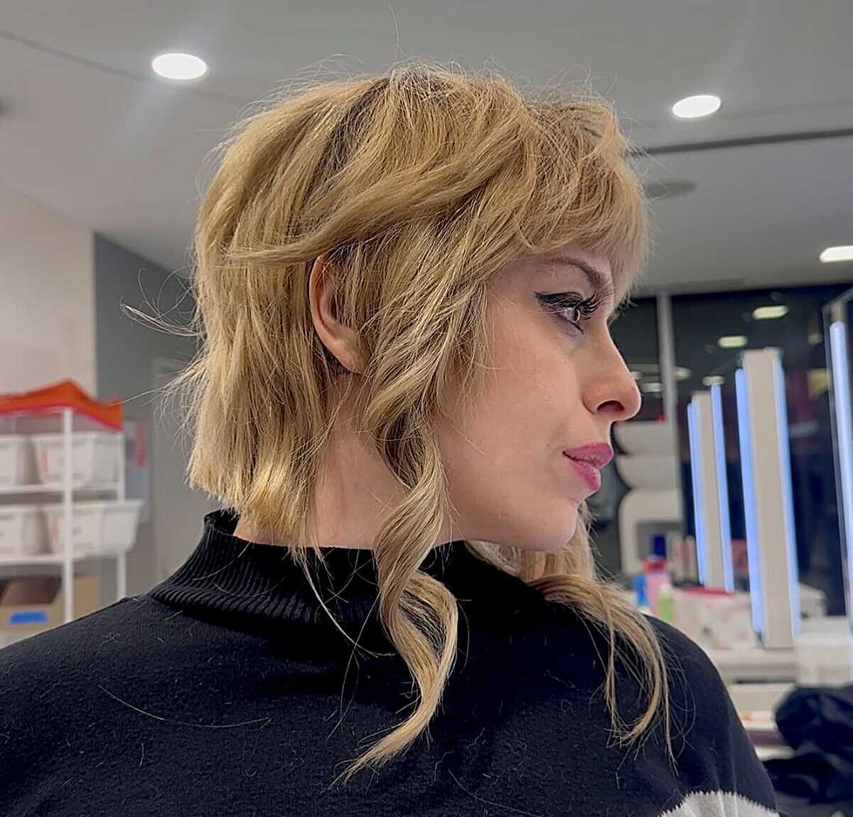 Side profile of warm blonde wavy shag with wispy bangs