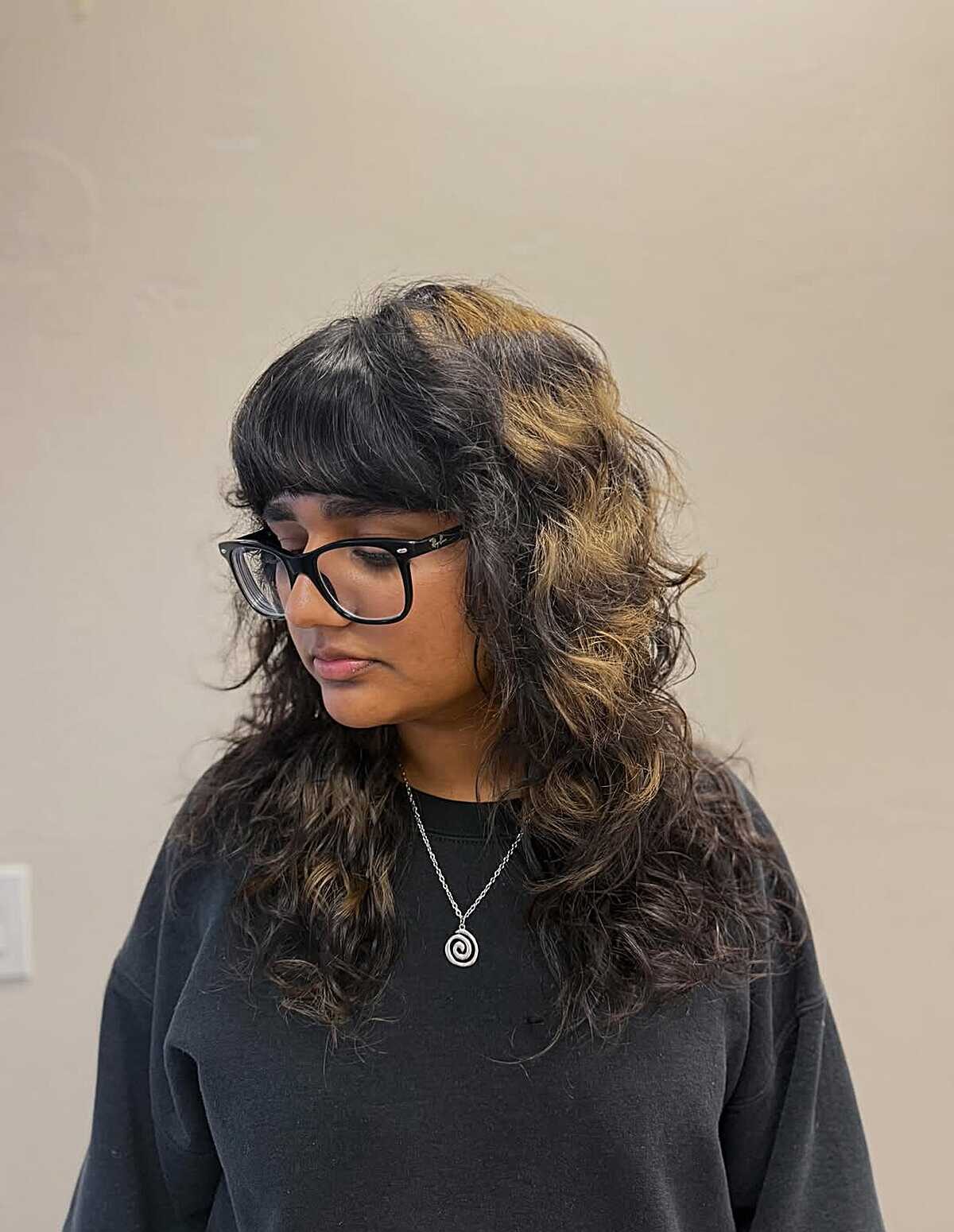 Long curly dark shag with honey blonde face-framing pieces