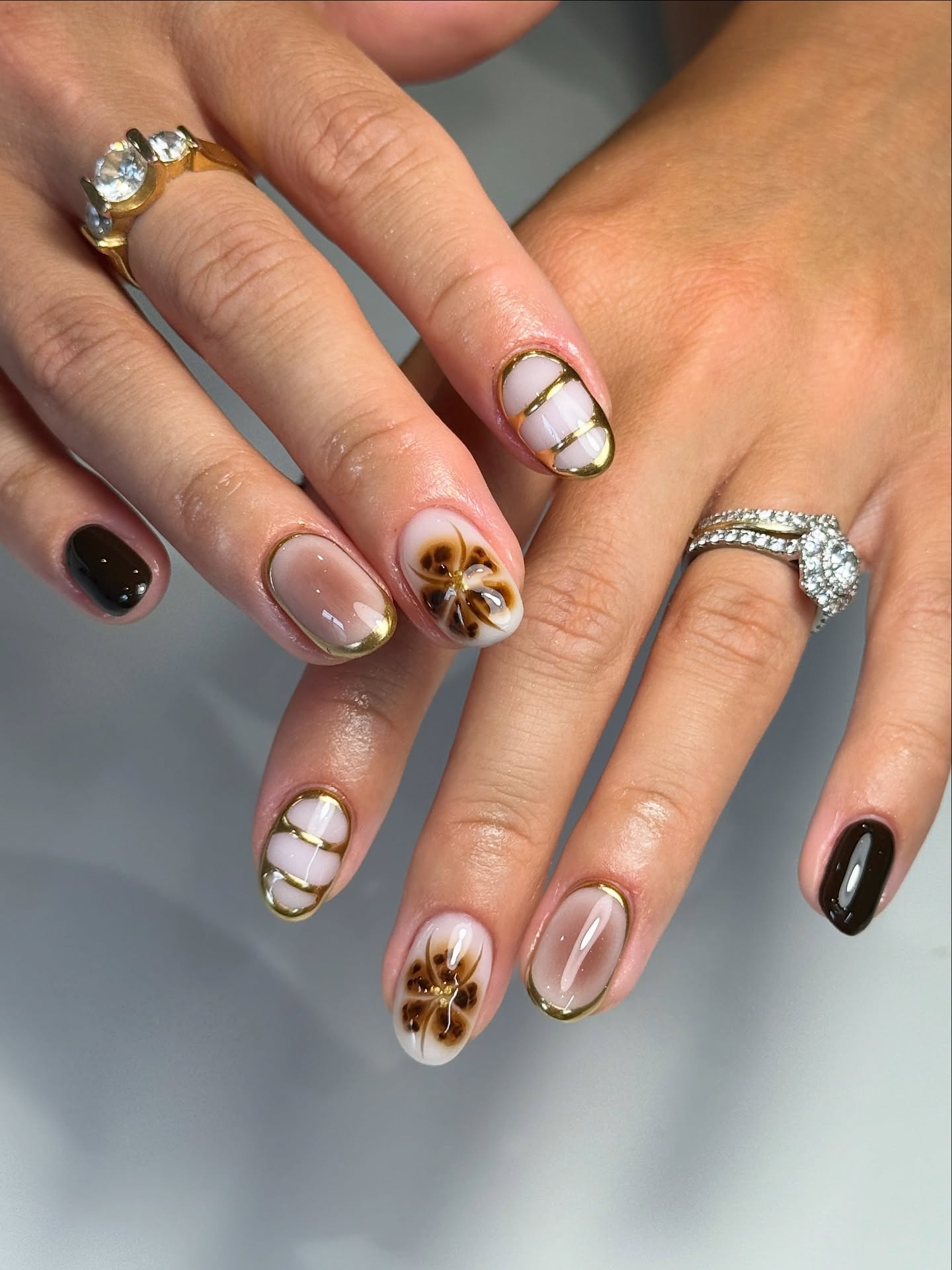 Brown Swirl Flower Oval Nails with Gold Outline