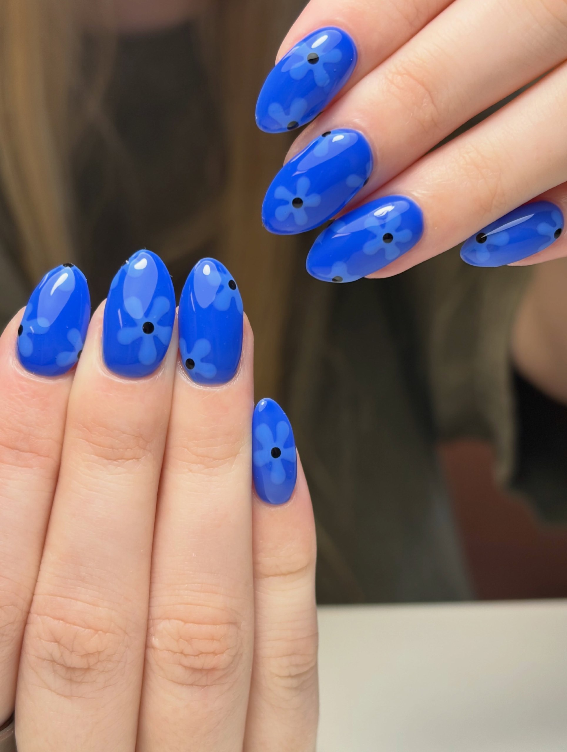 Vibrant Blue Oval Nails with Daisy Accents