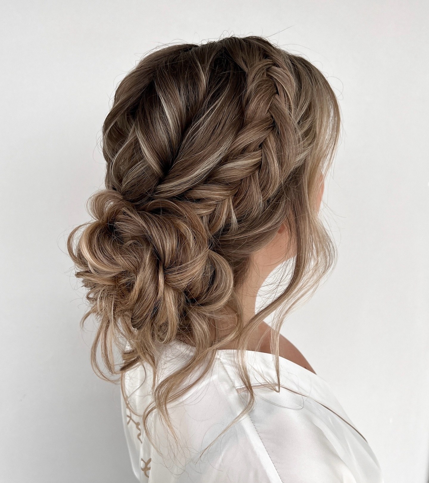 Messy Braided Low Bun With Face Framing Tendrils