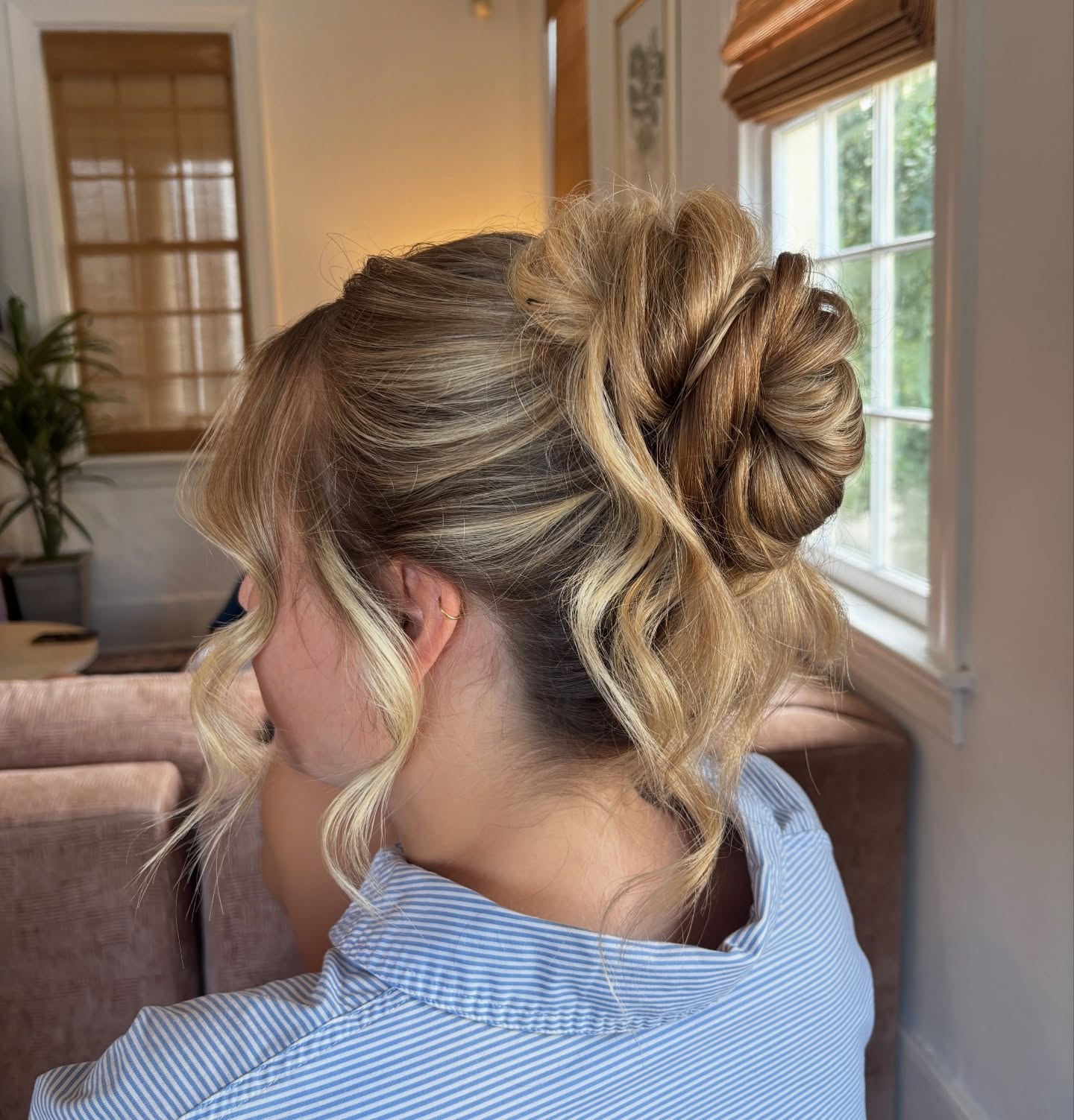 Messy Textured High Bun With Face Framing Tendrils