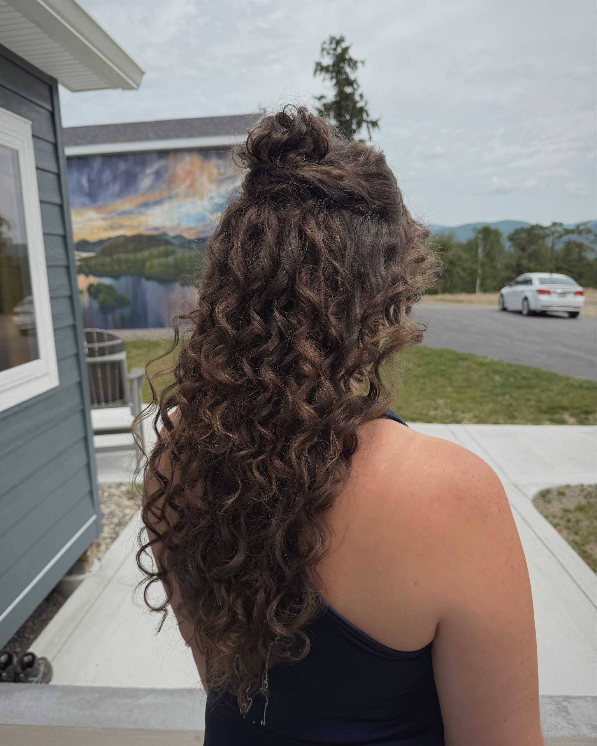 Half Up Messy Bun On Long Curly Brunette Hair