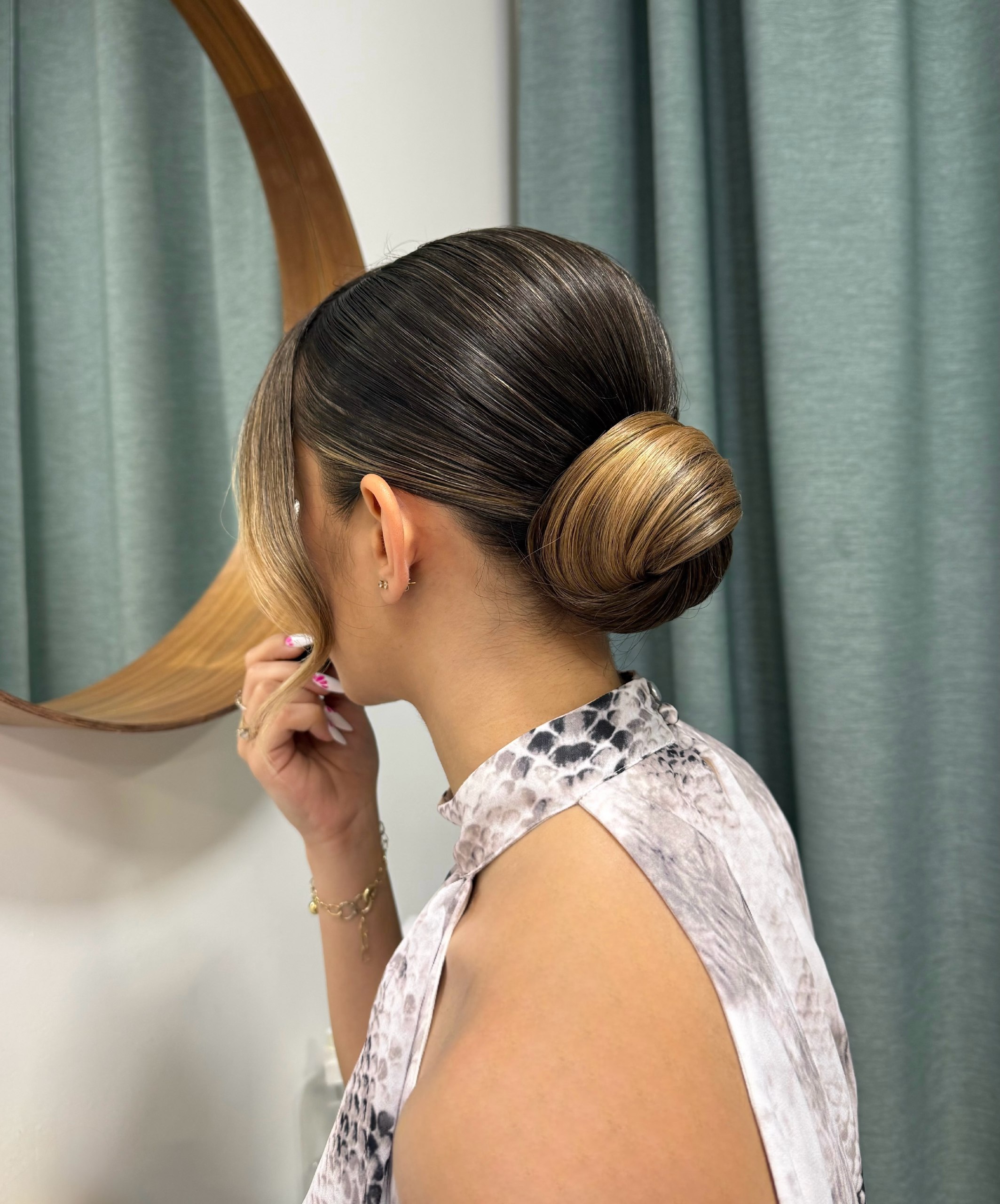 Sleek Honey Blonde Low Bun With Face Framing Pieces