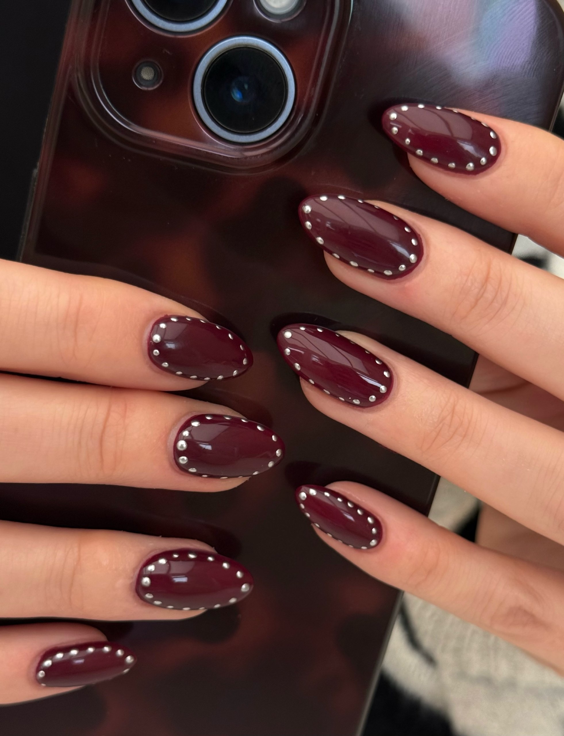 Burgundy Glossy Oval Nails with Silver Stud Accents