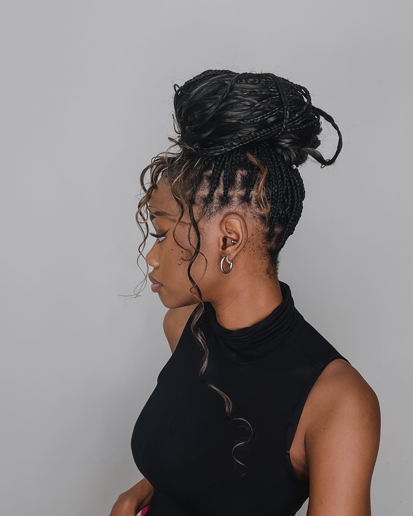 High Braided Bun With Face-Framing Tendrils