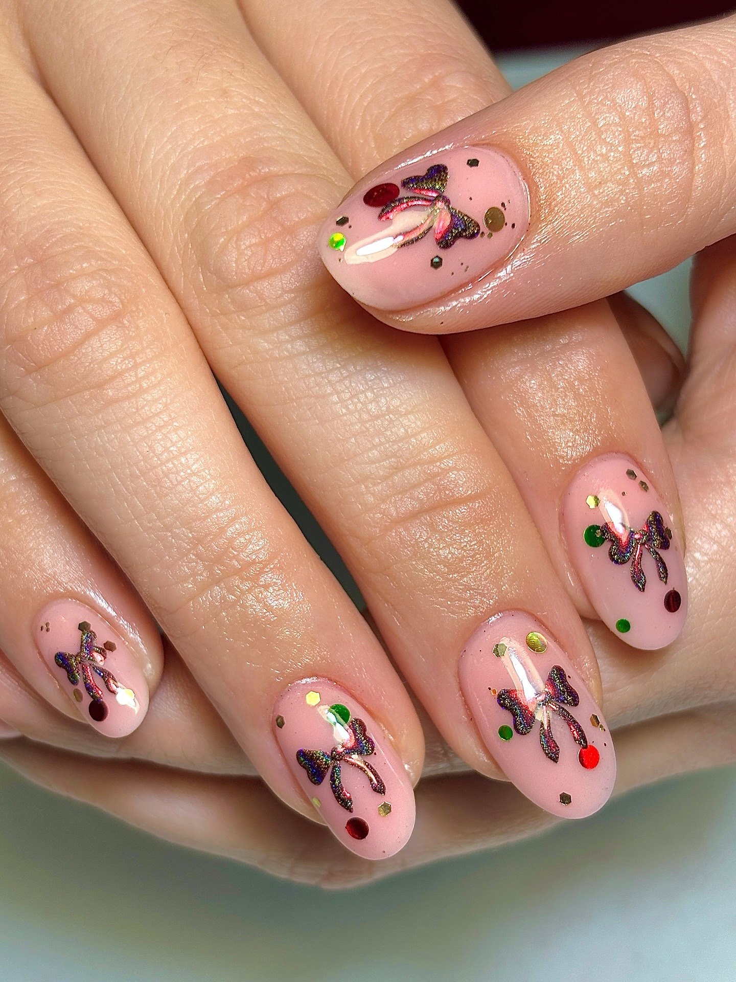 Glossy Nude Nails With Holographic Bows And Confetti