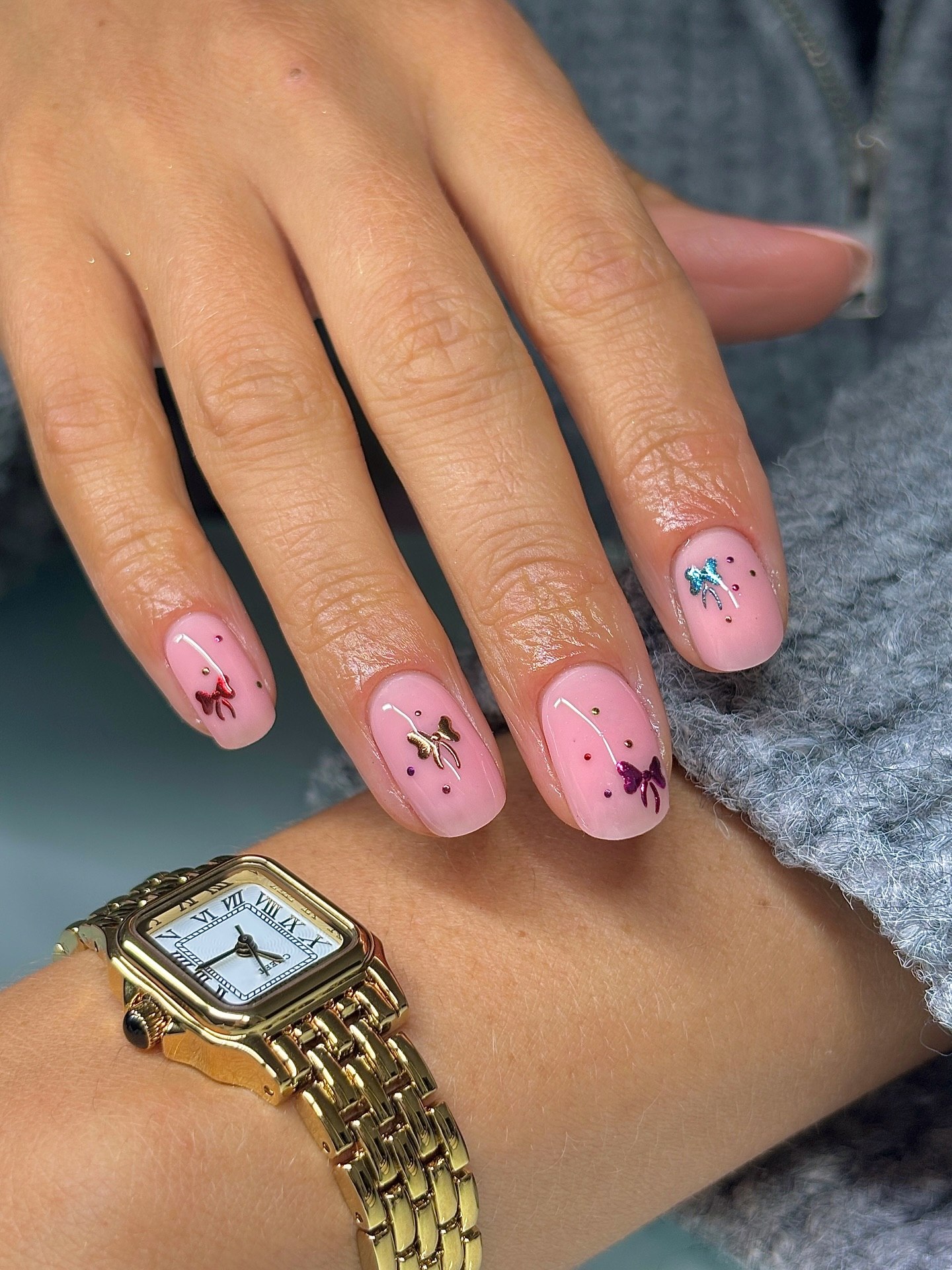 Glossy Pink Squoval Nails With Metallic Bows