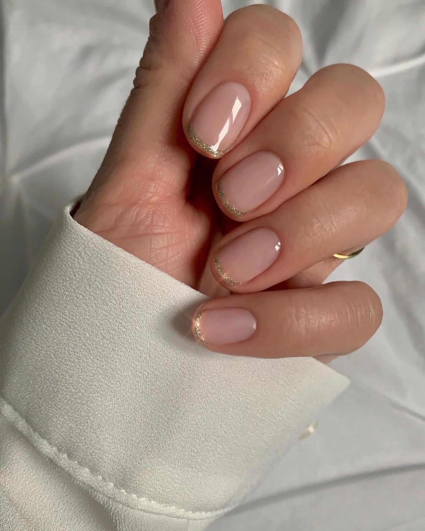 Sparkling Gold French Tip Nude Oval Nails