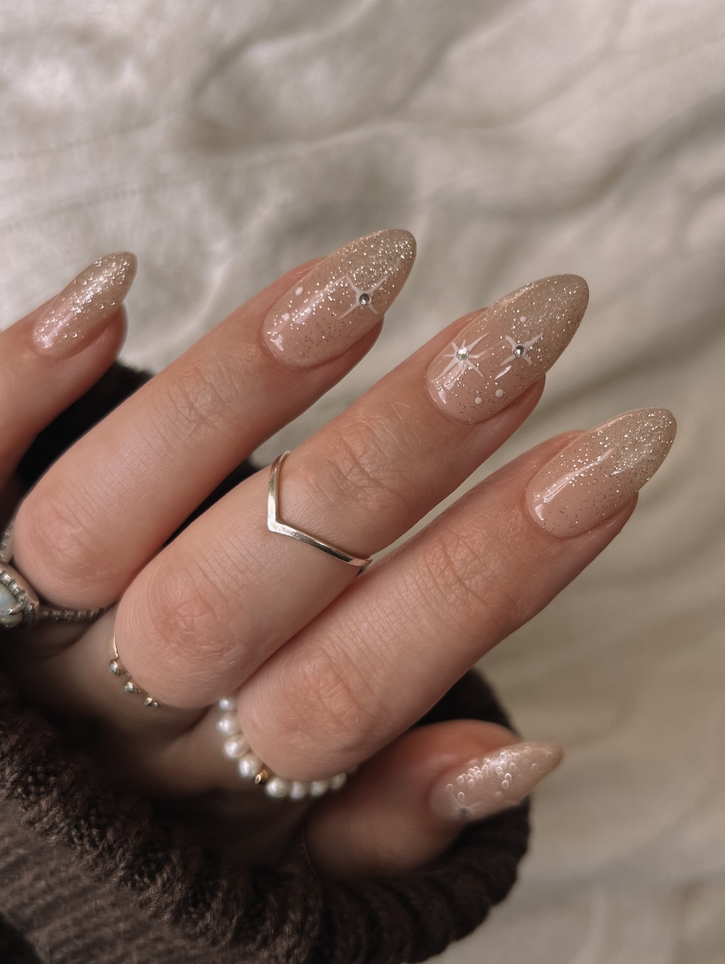 Glittery Neutral Almond Nails With Star Accents