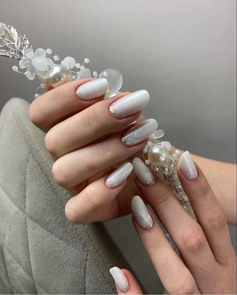Shimmering White Almond Nails With Gold Glitter Cuticle Accent — Winter White Nails