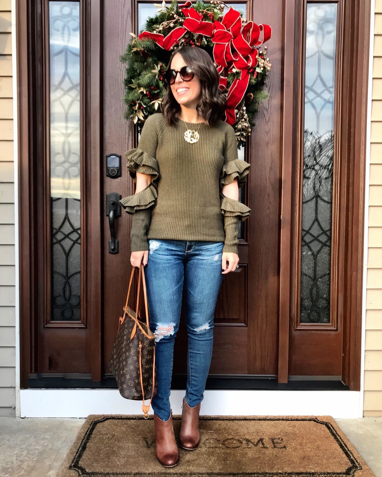 Green sweater with ruffled sleeves and distressed jeans — Christmas Eve Outfits