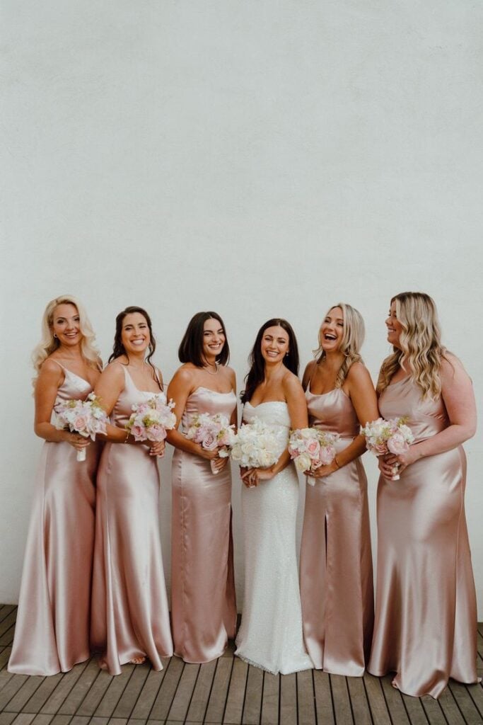 Matching Rose Gold Satin Slip Dresses With One Woman In A White Dress — Bridesmaid Dress Ideas