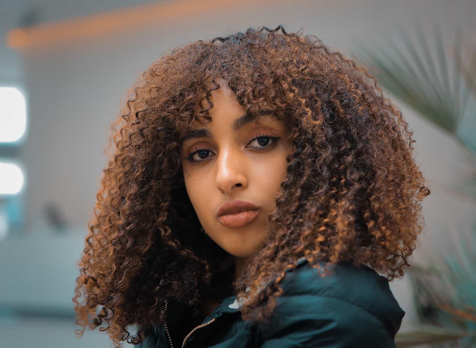 Collarbone Curls With Auburn Highlights and Curtain Bangs — Easy Curly Hair Routine